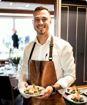 Un restaurateur souriant tenant des assiettes