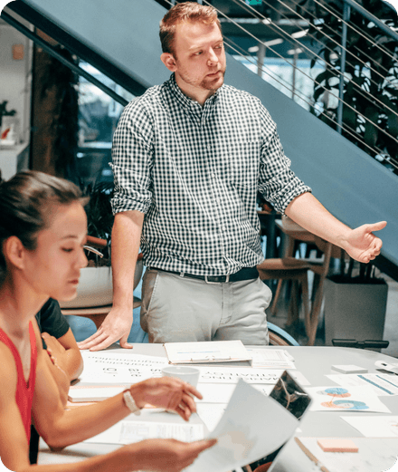 Un conseiller explique l’inscription à la TVA à une entrepreneuse autour d’une table de réunion