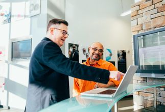 Two colleagues discussing something on a laptop