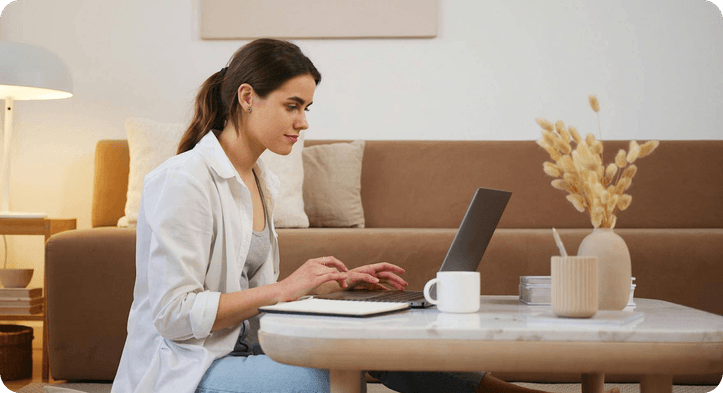 An entrepreneur working on her laptop in a bright living room
