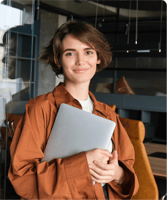Une jeune professionnelle tenant un ordinateur portable dans un bureau moderne